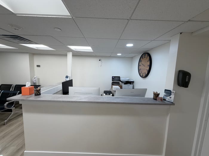 The front desk and reception area with a wall clock