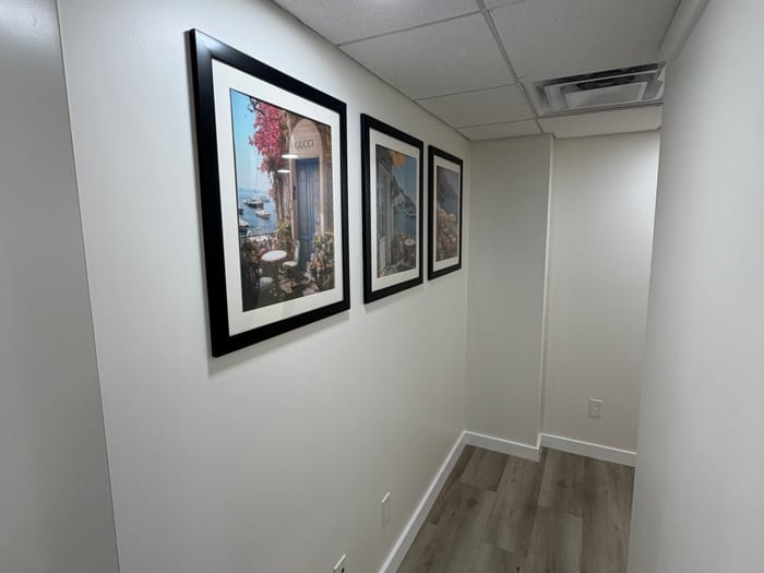 A bright hallway with three framed coastal prints on the wall